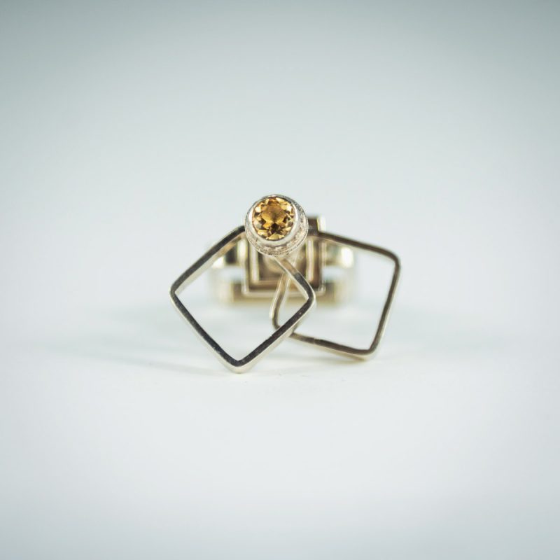 This is a stunning Kinetic Square Cocktail Ring! It has a square ring shank, sparkling citrine stone set in a decorative bezel, 2 square rings on top that like to spin around and will keep you and everyone around you mesmerized! Made from sterling silver and has a polished finish for a luscious look.