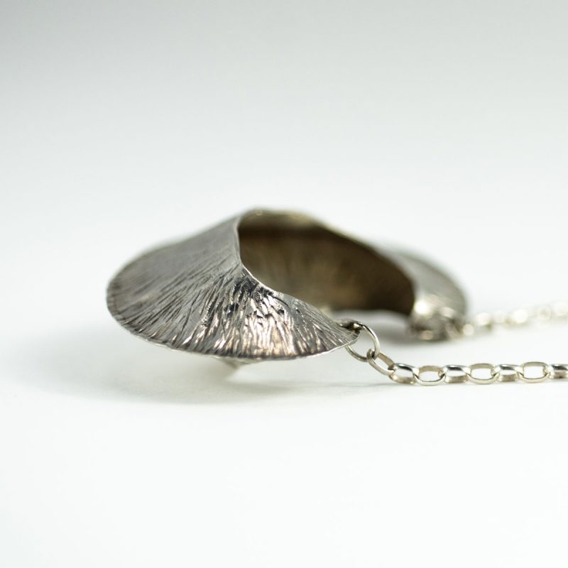 This striking of the Silver Pod Pendant is made from sterling silver and is perfectly lightweight. This is an elegant look for any day of the week! Side view