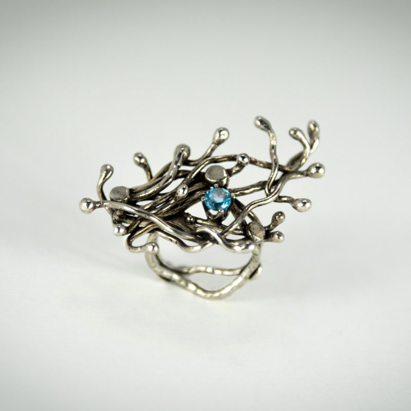 Top view of the wildly alluring Silver Sprout Ring is made from sterling silver and set with Blue Topaz Faceted Stone. Oxidized and polished for an eye-catching look!