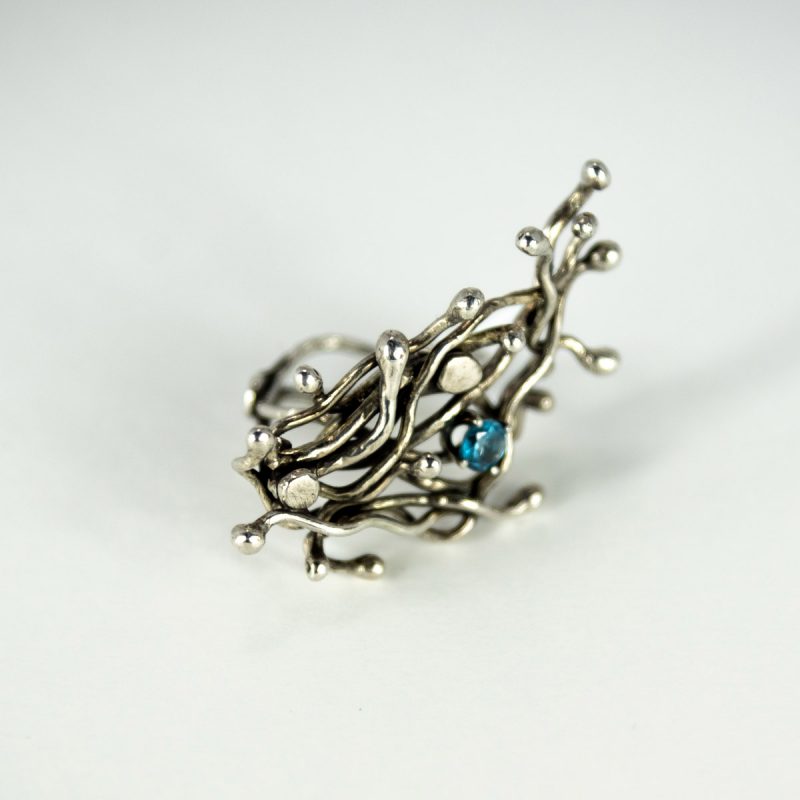 Side view of the wildly alluring Silver Sprout Ring is made from sterling silver and set with Blue Topaz Faceted Stone. Oxidized and polished for an eye-catching look!