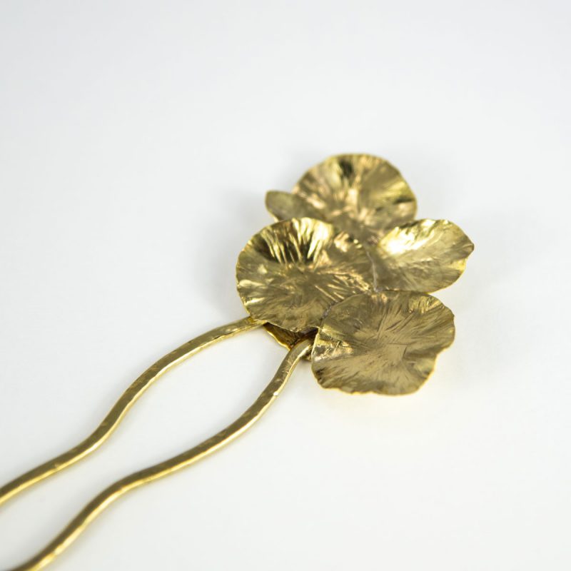 This stylish Brass Hair Fork Ikebana adds a bold artsy touch to a bun or any up-do hair styles. Overhead view.