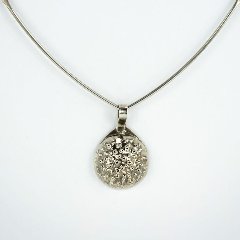 This charming Silver Orb Pendant is deceptively lightweight due to its hollow form construction. The silver orb has deep hammered textures, patina and a polished finish.